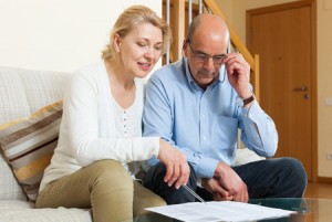 60234621 - serious elderly couple with financial documents in home interior